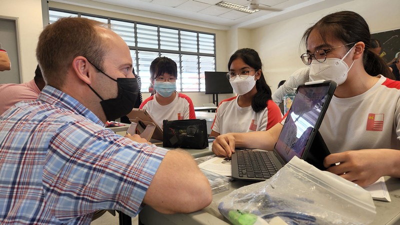 Students showing an educator their tablet computers.