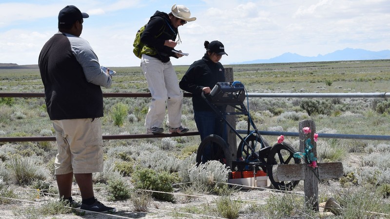 Researchers use a machine to collect ground-penetrating radar data in a desert cemetery.
