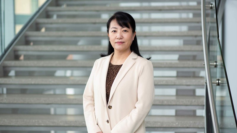 Rose Hu stands in front of a staircase.