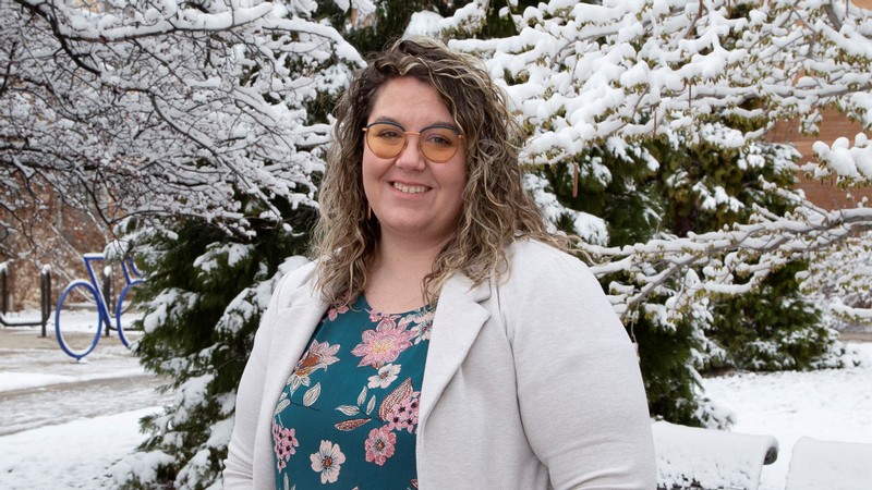 Cassandra McCall stands in front of a snowy tree on the USU Logan campus.