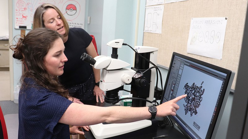 Researchers look at zircon grans with a stereoscope.
