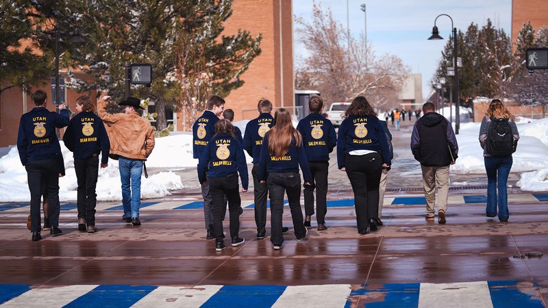 Students in FFA jackets cross the street.