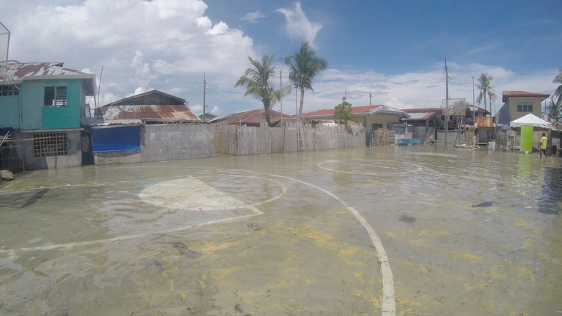 A flooded outdoor basketball court.