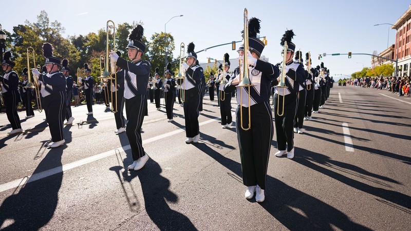 The USU marching band on a street.