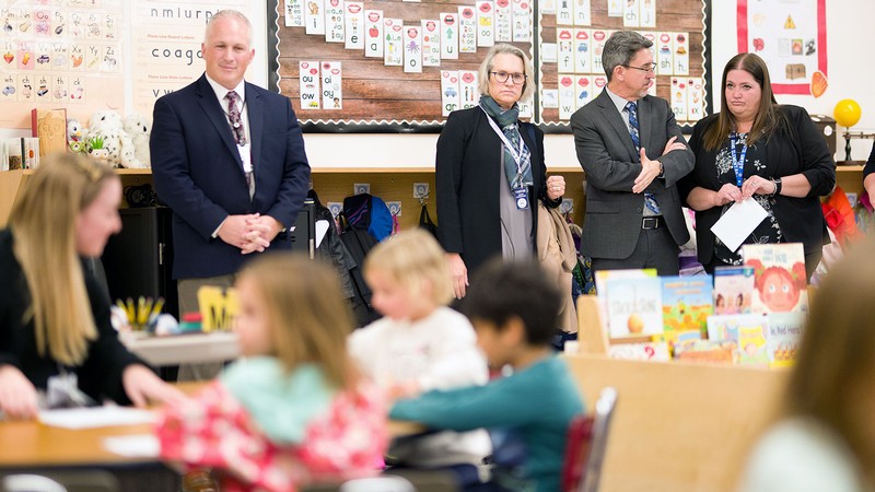 Education administrators observing an elementary classroom.