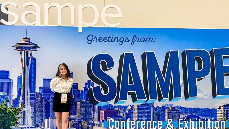 Crystal Tingle posing in front of a conference backdrop.