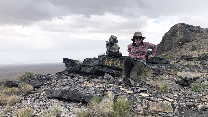 A geologist at a field site on a rocky ridge.