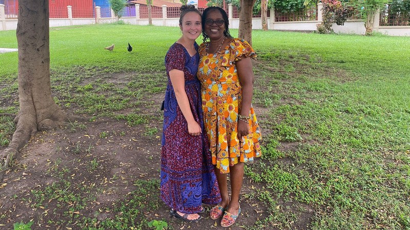 Two women standing in a clearing.
