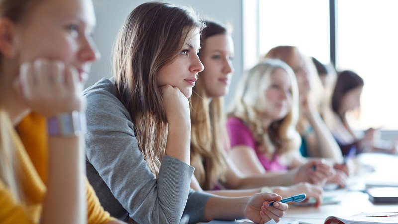 Women taking notes in a classroom.