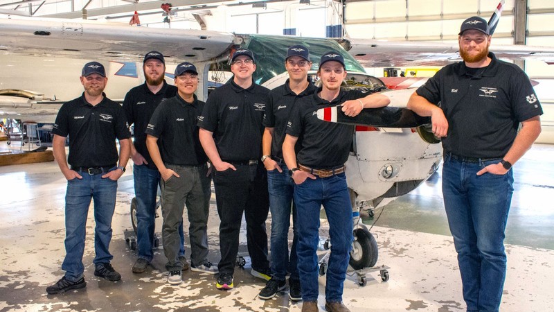 People standing in front of a small airplane.