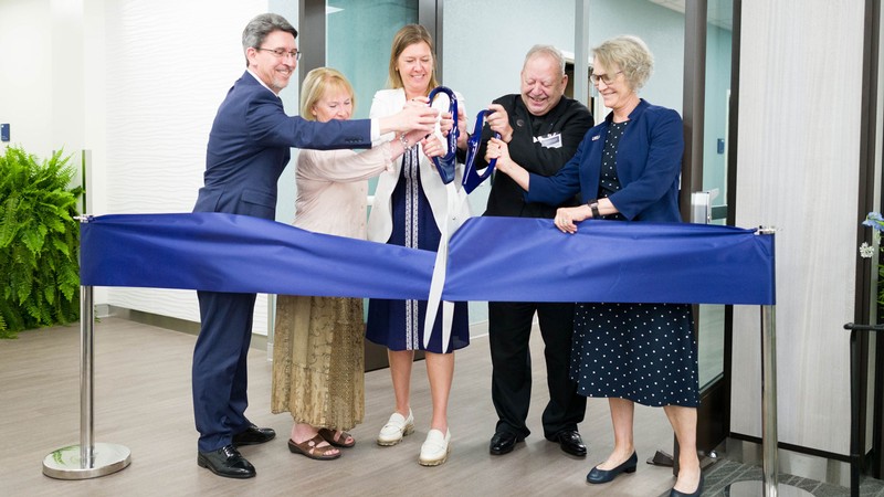 People cutting a giant ribbon.