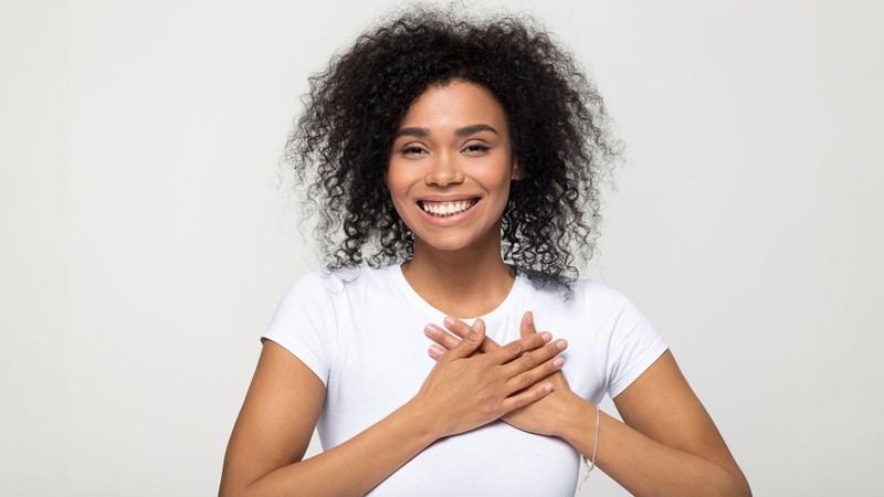 A person holding their hands over their heart.