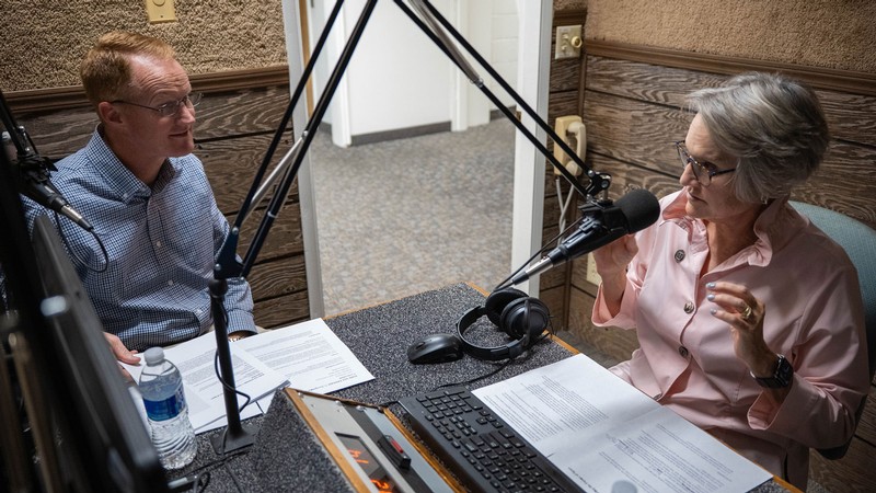 Jed Hancock and Elizabeth Cantwell talk in a recording studio.