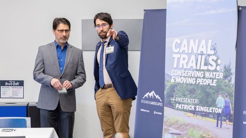 Two people speaking about canals at a research presentation.