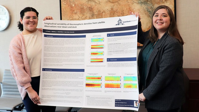 Two researchers with a poster.