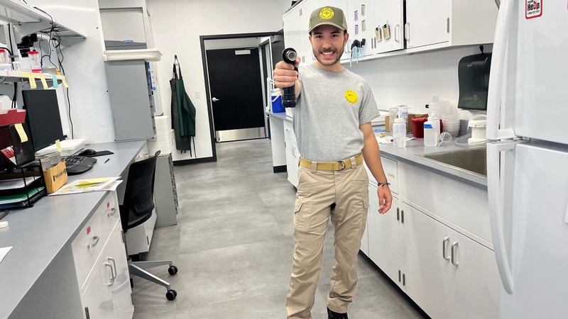 Biochemist holding aspirator.