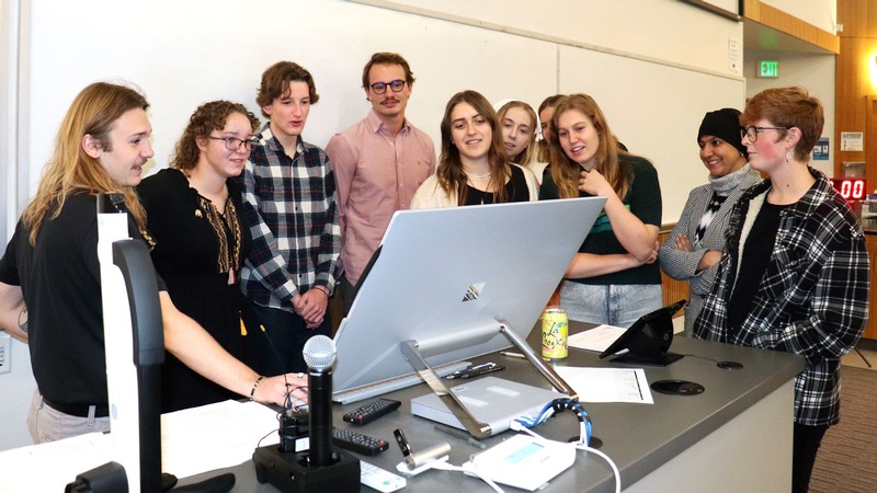 Students looking at a computer in a classroom.