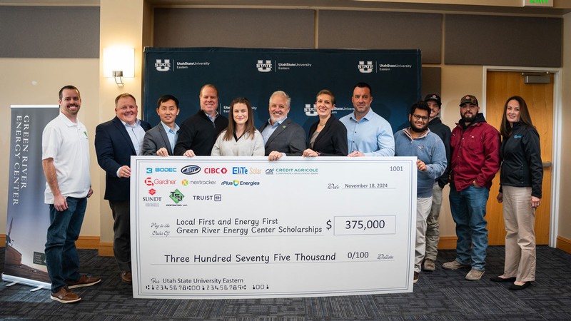 People posing behind a giant check for $375,000.