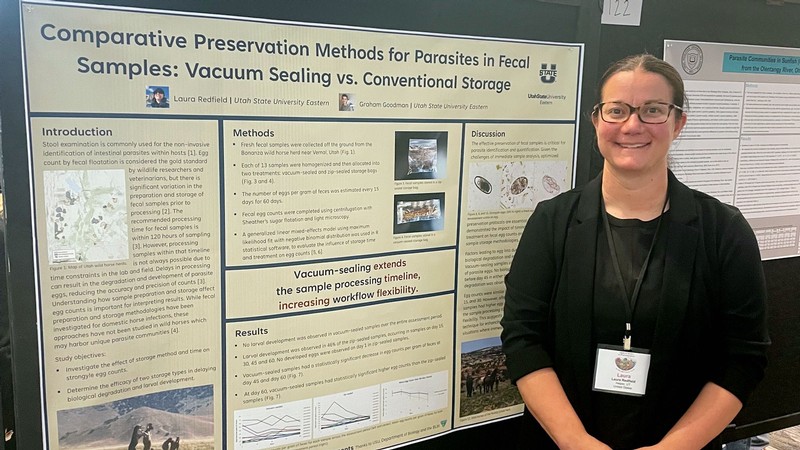 Laura Redfield standing by a research poster.