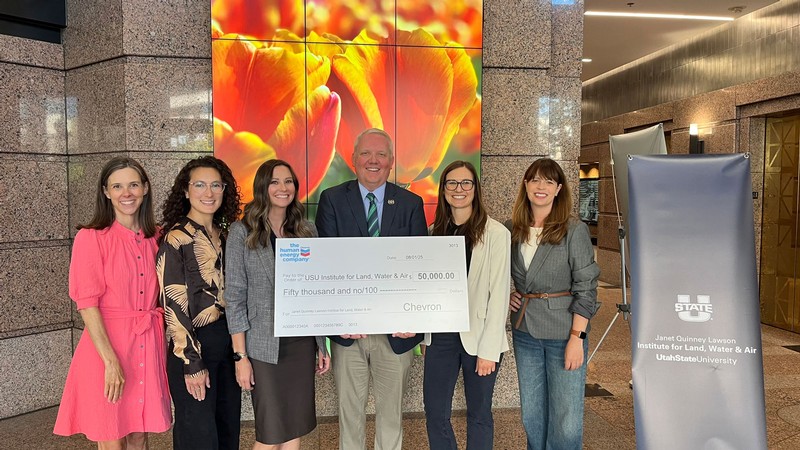 People holding a giant check for 50,000 dollars.