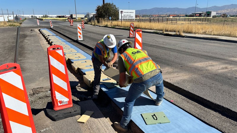 Workers installing embedded devices into a roadway.