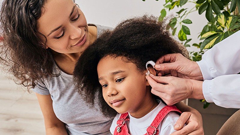 A child being fitted with a hearing aid.