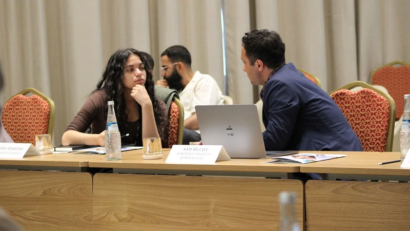 People speaking to each other at a conference in Uzbekistan.