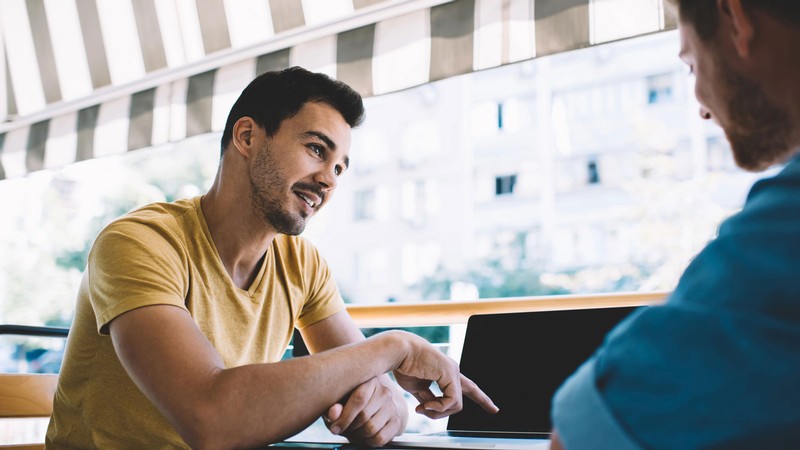 Two people talking at a cafe.