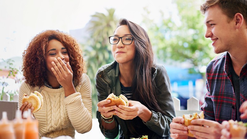 Three people eating at a restaurant.