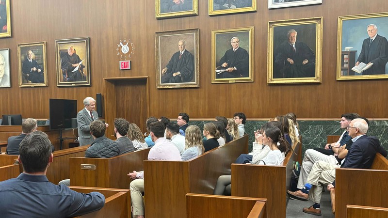 Students listening to a lecture in pews.