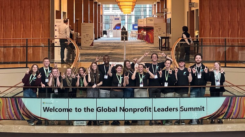 Students at a conference. Sign reads: Welcome to the Global Nonprofit Leaders Summit.