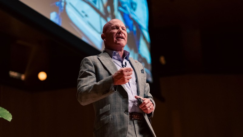 Rob Allen speaking on a stage.