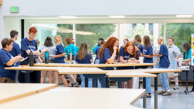 Students eating pizza at an activity.