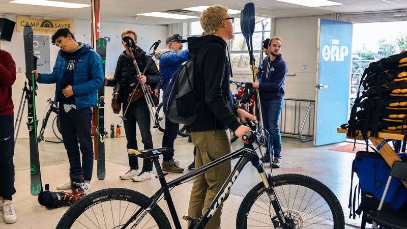 People standing in a line with outdoor equipment.
