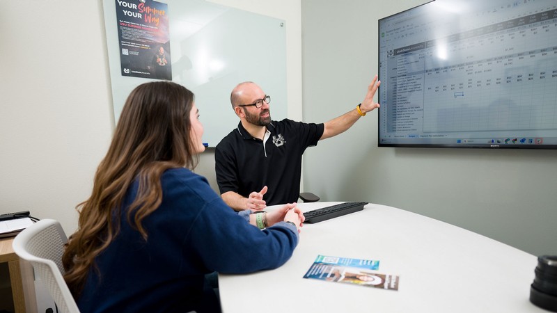 A student and a counselor discussing finances.