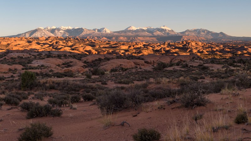 The sun rising over a redrock landscape.