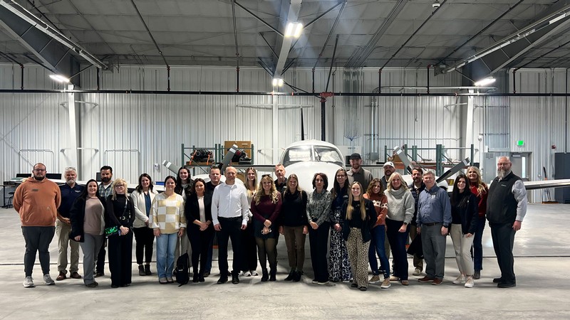 A group of people in an airport hangar.