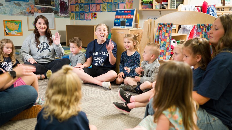 Adults and young children in a classroom.