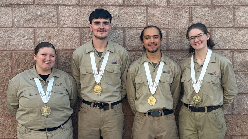 USU Eastern welders wearing SkillsUSA jumpsuits with medals.