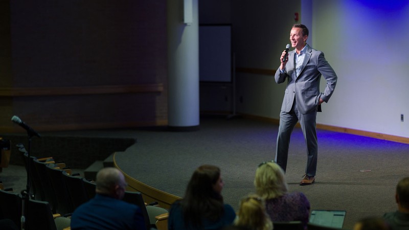 President Brad L. Mortensen speaking on a stage.