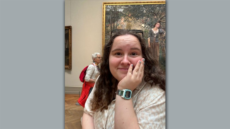 Elizabeth Leishman posing in front of a painting at a museum.