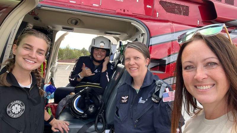 A crew posing for a photo in a helicopter.