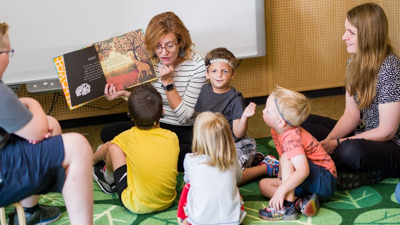 Teachers reading to children with hearing loss.