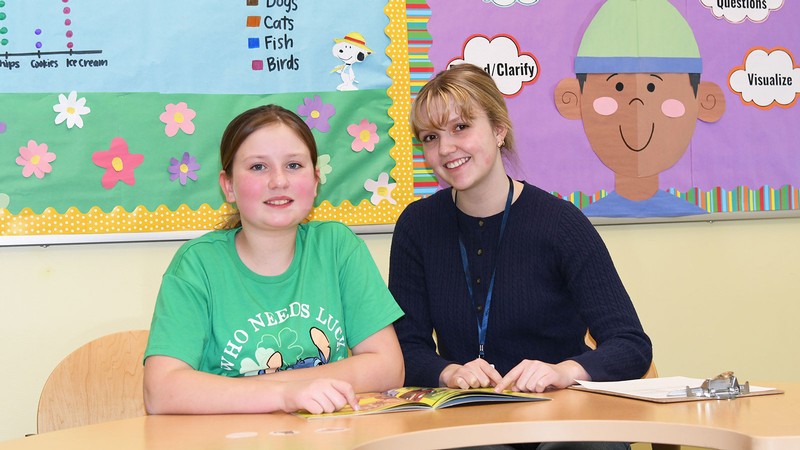 An educator and a student in an elementary classroom.