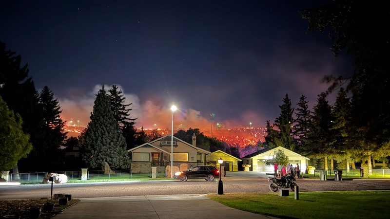 Wildfire burning behind a residential neighborhood.