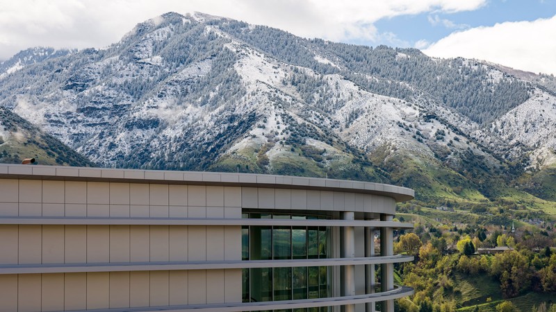 A large building in front of a snowy mountain.