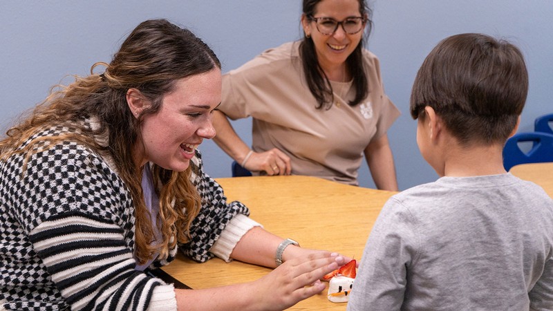 Adults doing a craft with a child.