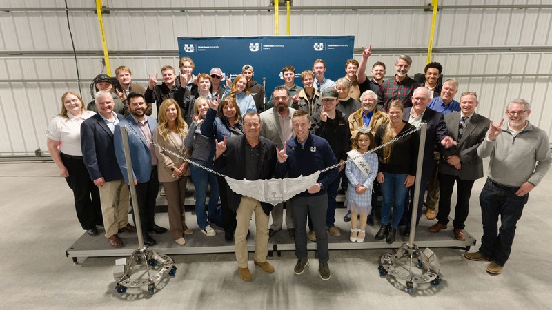 A group of people posing for a photo inside an aviation hangar.