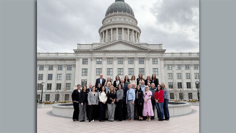 A group of students and educators posing for a photo outside the Utah Capitol.