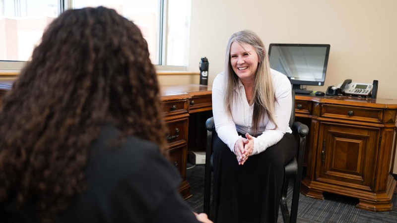 A student talking with a counselor in an office.
